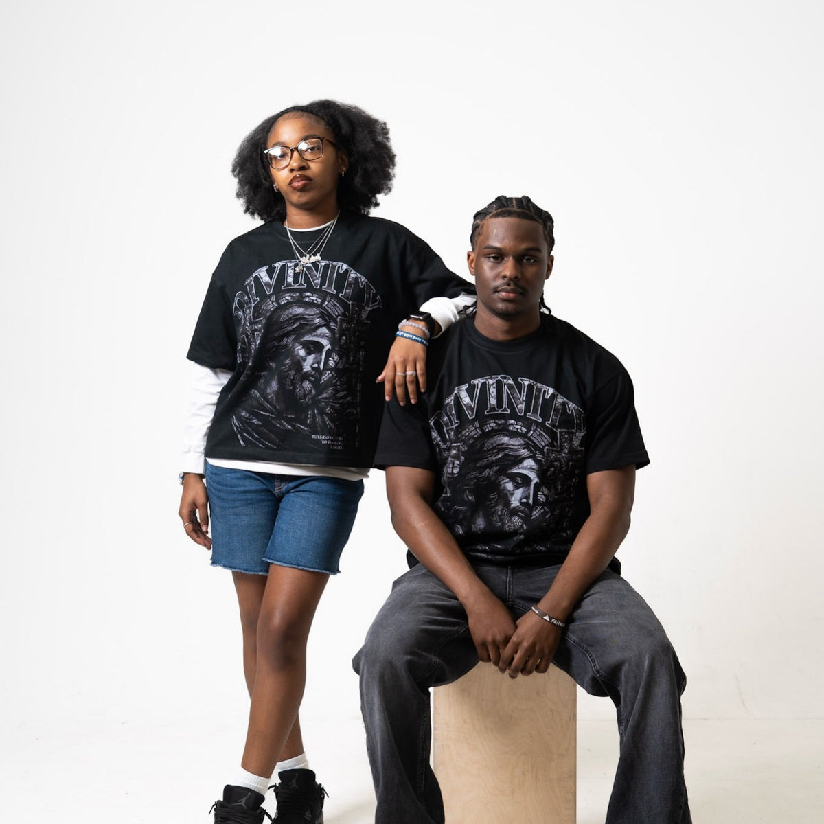 Two models wearing the DIVINITY Grace Over Guilt Tee