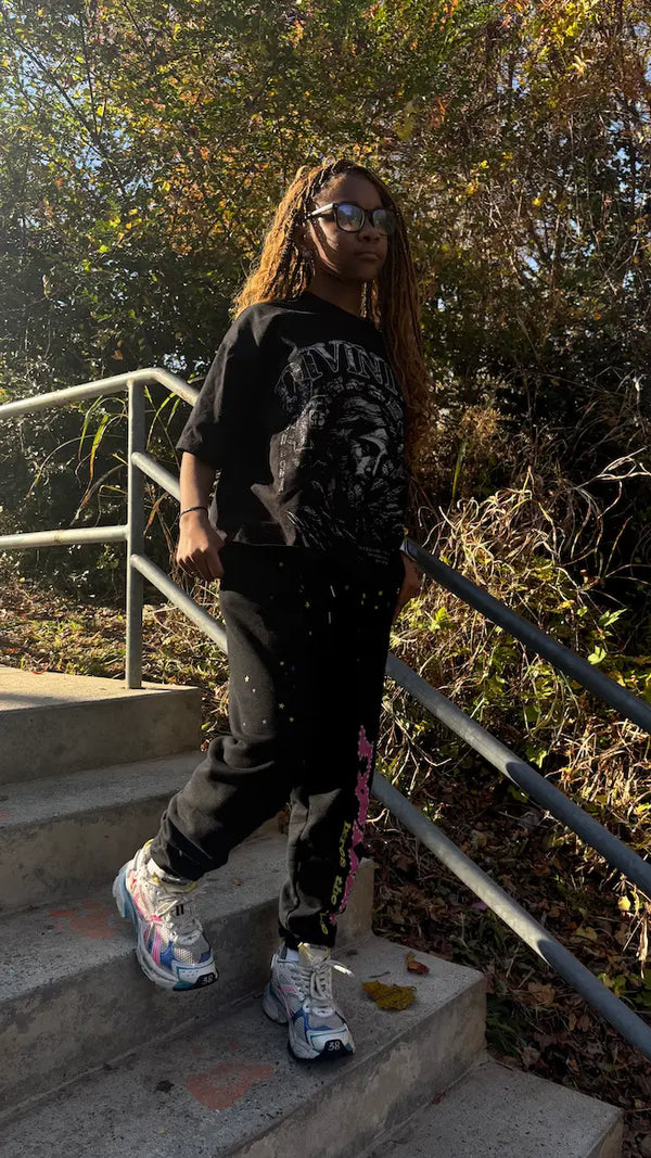 Person standing on steps outdoors with trees in the background